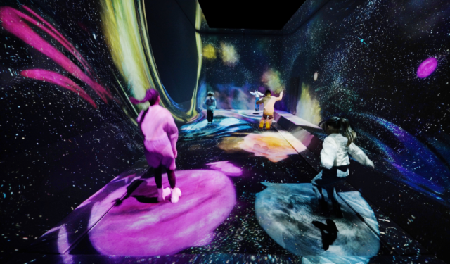 teamLab, Multi Jumping Universe (c) teamLab - Multi Jumping is a flexible surface that people can jump on, and sink or jump higher than usual. When you stand on Multi Jumping, the surface beneath your feet sinks, creating warps in space and time. This distortion attracts stardust from the universe and births new stars. If you jump on top of a star, it begins to move, and if you continue to jump on the star it will grow and you will be able to experience the entire life cycle of the star.